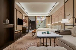 上海上海前滩香格里拉的酒店客房配有床、沙发和桌子。