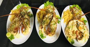 本托塔雅努斯天堂休憩住宿加早餐旅馆的两盘带虾和薯条的白盘食物