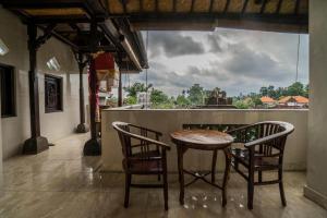乌布Bangbang Guest House Ubud的享有美景的客房内配有一张木桌和椅子。