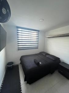布卡拉曼加Habitación Auxiliar en Apto Compartido piso 26的一间卧室设有一张黑色的床和一个窗户。