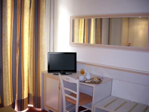 米兰阿德勒酒店的客房设有书桌、电视和椅子