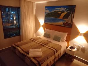 纳塔尔Ilusion Flats Aconchego de Ponta Negra的酒店客房,配有一张带两盏灯的床