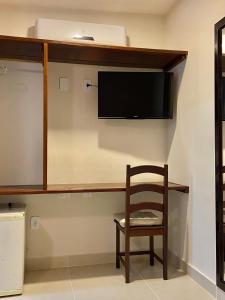 萨夸雷马Pousada OCEAN的一间房间,墙上有椅子和电视