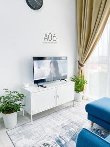 加影SUWAN Guesthouse A06 - 2BR Apartment with Pool Near UKM的一间客厅,在白色的橱柜上配有电视