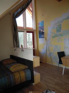 Oude Pekela佐梅尔布腾住宿加早餐旅馆的一间卧室配有一张床、一张书桌和一个窗户。