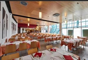 塞斯特雷Olimpic Village TH Sestriere apartments的宴会厅配有桌椅和红色餐巾