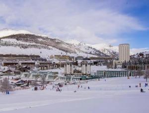 塞斯特雷Olimpic Village TH Sestriere apartments的一群人在雪覆盖的山上滑雪