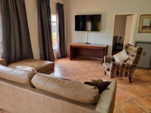 DalmadaPecan Nut Place的客厅配有棕色真皮沙发和椅子