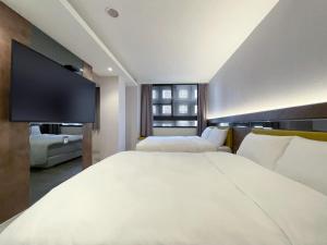 台中市雀客旅馆台中青海的酒店客房设有两张床和一台平面电视。