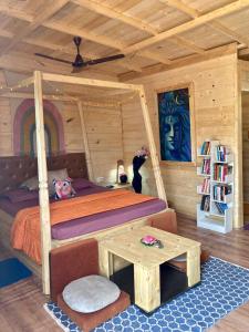 阿姆波尔Love Temple Beach Resort的小木屋内的卧室,配有一张床和一张桌子