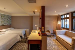 台北Rich & Free Hotel - Kaifeng 富逸旅趣-北車開封館的酒店客房,设有两张床和一张沙发