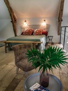 马尔泰勒Les Hauts de Bagadou的一间卧室配有床、椅子和植物