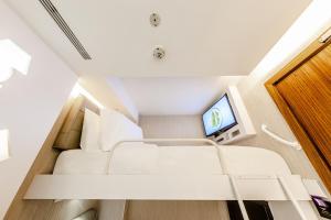 新加坡D'Nova Hotel Bugis的小房间设有床铺和电视