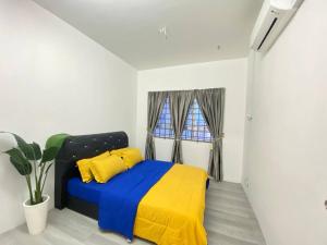 瓜拉丁加奴Homestay Kuala Terengganu Affan01 Dekat Pantai Batu Buruk的一间卧室配有一张蓝色和黄色毯子的床