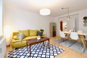 维也纳Central Vienna Charm - Comfortable 3-BR Stay的客厅配有黄色的沙发和桌子