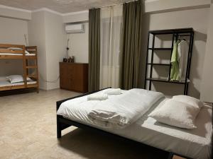 第比利斯Babilon Hotel Tbilisi的一间卧室配有带白色床单和枕头的床。