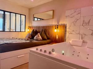 第戎Le Nid de la Chouette - Gare & Cité by Apparts Spa Dijon的一间卧室配有一张床和浴缸