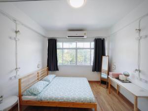 大城Room Story Hostel的一间卧室配有一张床、一张书桌和一个窗户。