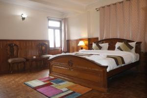 甘托克Hotel De Villa Gangtok的一间卧室设有一张大型木床和一个窗户。