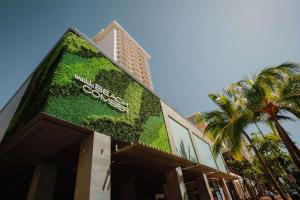 檀香山OUTRIGGER Waikiki Beachcomber Hotel的一座有绿色墙的建筑,上面有标志