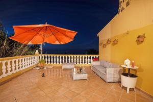 La Victoria de AcentejoCasa La Victoria的阳台的庭院配有橙色遮阳伞