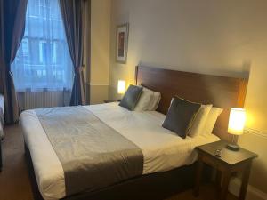 伦敦卡文迪什酒店的一张大床,位于酒店带两盏灯的房间