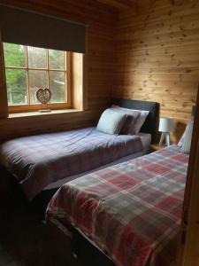 基斯Norwegian Log Cabin The Roe Deer -sauna & hot tub的小木屋内一间卧室,配有两张床