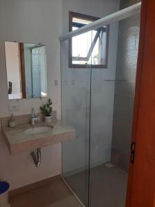 乌巴图巴Suítes Canola的带淋浴、盥洗盆和镜子的浴室
