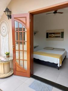 乌巴图巴Suítes Canola的一间卧室设有一张床和一个开放式门