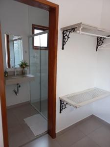 乌巴图巴Suítes Canola的一间带玻璃淋浴和水槽的浴室