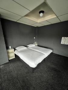 RogatHotel de Raket的一张大床,位于一个黑墙的房间