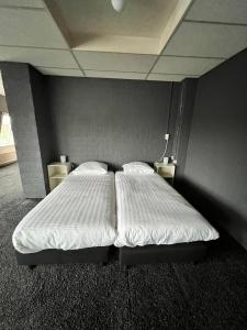 RogatHotel de Raket的一间卧室配有一张带白色床单的大床