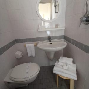里米尼卡万尼酒店的白色的浴室设有卫生间和水槽。