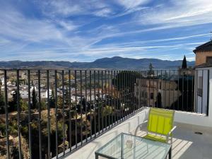隆达Apartamentos Casa-Palacio Santa Pola的阳台设有玻璃桌,享有城市美景。