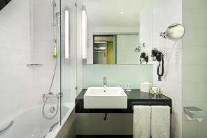 伯尔尼伯尔尼韦斯特赛德假日酒店的白色的浴室设有水槽和浴缸。