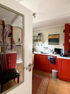 胡苏姆Ahoi Husum, anlegen und wohlfühlen的厨房配有红色橱柜和镜子