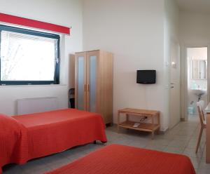 特拉莫竹屋旅馆及公寓的一间卧室设有一张床、一个窗口和一台电视