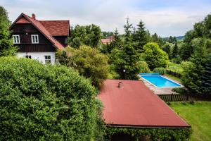 Lomnice nad PopelkouChalupa nad Popelkou的享有红色屋顶房屋和游泳池的空中景致