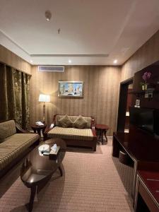吉达EKONO by Leva Jeddah Airport Hotel的客厅配有沙发和桌子