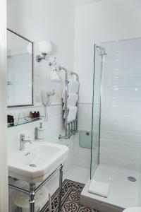 里加Sherlock Apartments的白色的浴室设有水槽和淋浴。