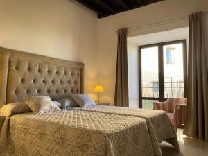 隆达Apartamentos Casa-Palacio Santa Pola的一间卧室设有一张大床和大窗户