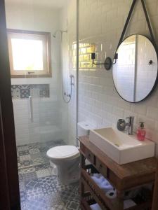 兰舒凯马杜Cabana Guimarães的一间带卫生间、水槽和镜子的浴室