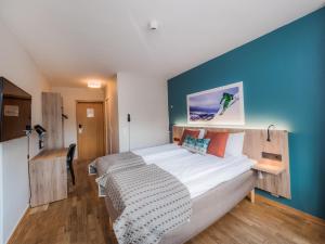 努尔菲尤尔埃德Nordfjord Hotell的一间卧室设有一张蓝色墙壁的大床