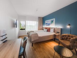 努尔菲尤尔埃德Nordfjord Hotell的配有一张床和一把椅子的酒店客房