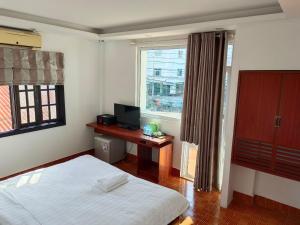 万荣Vang Vieng Trendy Hotel的一间卧室配有一张床、一张书桌和一个窗户。