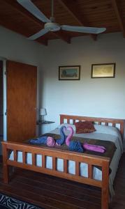 吉亚迪诺镇Del Carmen的一间卧室配有一张木床,床上有粉色蛇