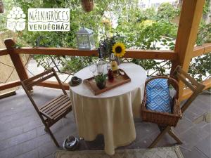 大毛罗什Málnafröccs Vendégház Nagymaros的天井上配有带向日葵和玻璃杯的桌子