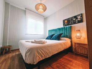 Palazuelos de EresmaCasa Robledo的一间卧室配有一张大床和蓝色床头板