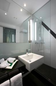 伯尔尼伯尔尼韦斯特赛德假日酒店的白色的浴室设有水槽和淋浴。