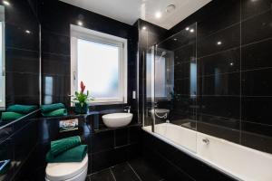 伦敦London Nino Apartments的浴室配有卫生间、盥洗盆和浴缸。